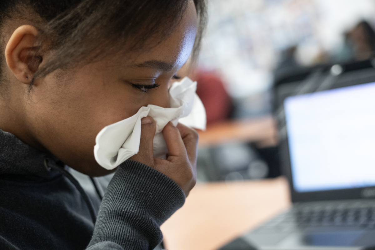 Kristiauna Brown (10) blows her nose in a tissue to prevent germs.